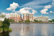 Christiana River waterfront in Wilmington. Rows of houses and clouds are reflected in the water.