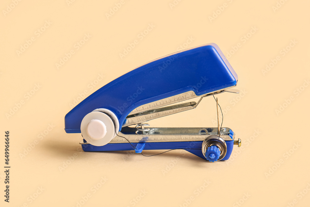 Manual sewing machine on beige background