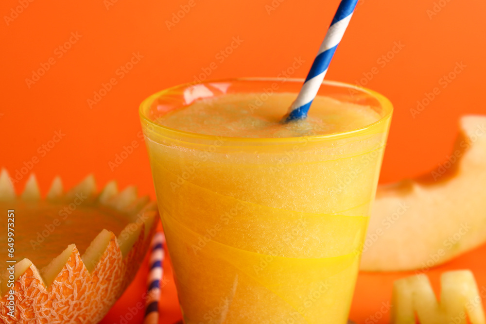 Glass of tasty melon smoothie on orange background