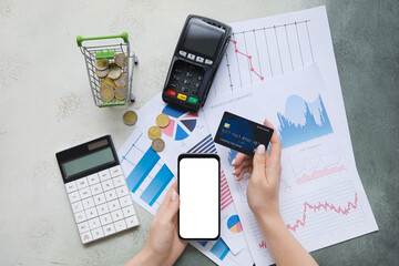 Sticker - Female hands with smartphone, credit card, calculator and charts on grey grunge background. House rent concept