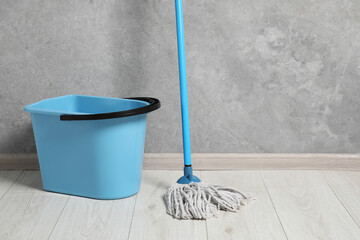 Sticker - Mop and plastic bucket indoors. Space for text