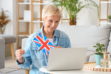 Canvas Print - Mature woman with UK flag learning English language online at home