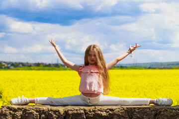 smiling teenage child sitting on a twine. good health concept. girl in nature, lifestyle.
