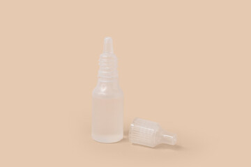 Bottles of nasal drops on beige background