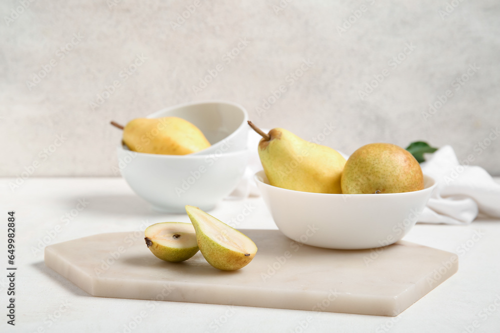 Bowl with ripe pears on white background