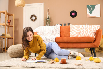 Canvas Print - Young woman reading book at home on autumn day