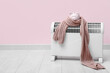 Leinwandbild Motiv Electric convector heater, piggy bank and scarf near pink wall. Heating season
