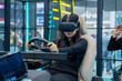 Woman wearing VR headset having fun while driving on car racing simulator