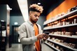 shot of a young man using his phone while shopping in a modern store