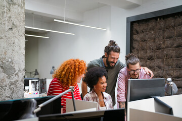 Wall Mural - Diverse group of professionals meeting in office. IT programmers use computer, talk strategy