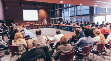 Wall Mural - Speaker giving a talk on corporate business event. Audience at the conference hall. Business and Entrepreneurship event. Focus on unrecognizable business people in the rear.