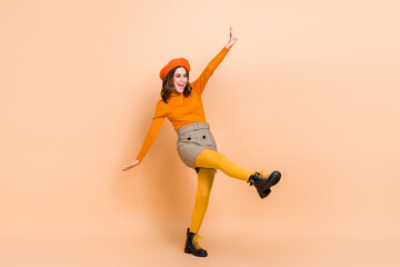 Poster - Full length photo of cheerful lady wear orange clothes good mood look empty space celebrate big sale isolated on beige color background