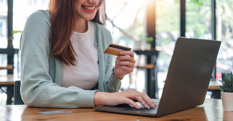 Asian woman using laptop computer and credit card for shopping online