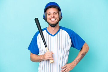 Wall Mural - Baseball player with helmet and bat isolated on blue background posing with arms at hip and smiling