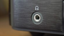 Connecting Headphones to Headphone Jack Slot in Stereo Set Close-Up