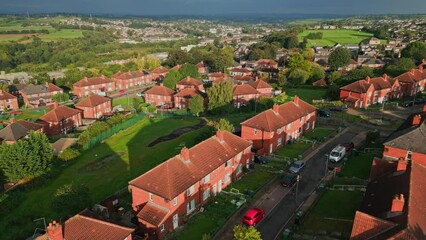 Wall Mural - Yorkshire urban dwellings: Red brick council estate, aerial drone, sunny morning, bustling streets, community life.