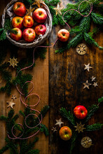 Christmas Decoration With Apples, Fir Branches And Straw Stars On A Wooden Background