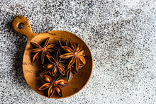 Anise Star Spice For Baking In Wooden Spoon On Concrete Table