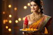 © PRASANNAPIX - Indian woman holding sweet meal or laddoo thali. Celebrating diwali festival.