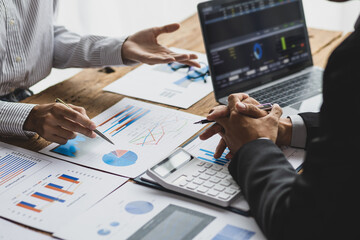 Business advisory meeting discussing analyzing company growth using business reports and financial charts. Brainstorming, analyzing strategies and planning investments.