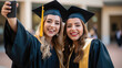 © Studio Nova - Happy smiling graduating girlfriends in an academic gowns standing in front of college