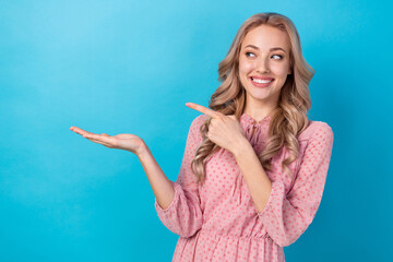 Sticker - Photo of pretty woman with wavy hairdo dressed pink clothes look indicating at sale on arm empty space isolated on blue color background