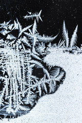 Poster - White frost pattern on a window glass over dark background, macro photo