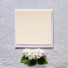 Sticker - Happy birthday, mother's day, wedding composition. Blank greeting card, invitation and envelope mockup. Rectangular blank with delicate lilac flowers. Flat lay, top view.