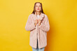 © sementsova321 - Yes I gained my goals. Joyful smiling brown haired girl wearing pink fur coat with ponytails shaking clenched fists celebrating win or success enjoying victory isolated over yellow background
