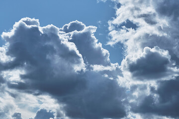 Wall Mural - Clouds against blue sky are illuminated by bright summer sun.