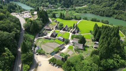 Canvas Print - Aerial over Japanese village, small houses with trees by the river