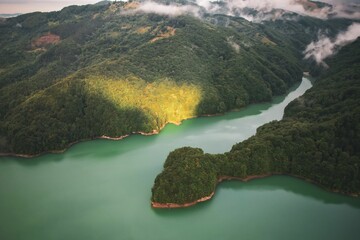 Poster - some water and trees in the middle of a mountain range