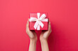 © ADDICTIVE STOCK - A woman's hands holding a red gift box with a white bow created with Generative AI technology