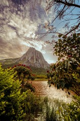 Sticker - A backdrop of majestic mountains and a large rock in the foreground