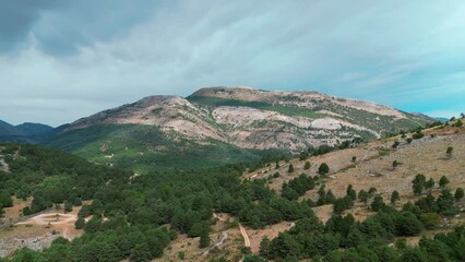 Wall Mural - landscape scene over valley of green rocky hills and mountains under blue cloudy sky