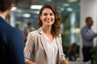 © Impressionstock - Happy businesswoman smiling to client in office. A Happy Businesswoman Greets Her Client with a Warm Smile in the Office