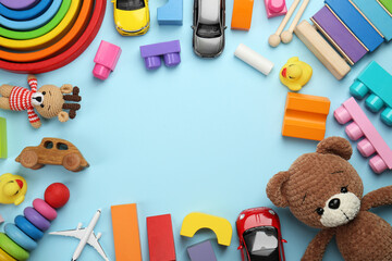 Wall Mural - Frame of different children's toys on light blue background, flat lay. Space for text