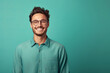 Portrait of young smiling man wearing glasses isolated on turquoise background with space for inscriptions or text.generative ai
