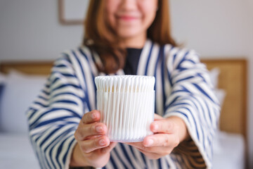 Wall Mural - Closeup image of a woman holding and showing a cotton buds at home