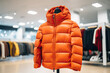 Close-up of an orange down jacket in a store