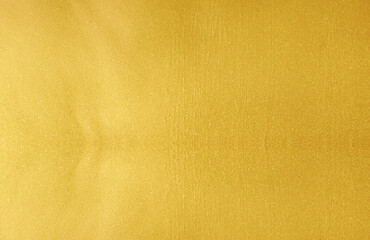 Wall Mural - Gold wall texture background. Yellow shiny gold foil paint on wall surface with light reflection, vibrant golden luxury paper wallpaper