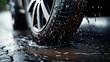 Car wheel in rain, dripping wet tire underside closeup portrait with road background
