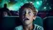© ND STOCK - Little boy in a white shirt watching a movie for the first time in a movie theater, looking excited at the screen because he has discovered something new.