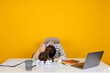Tired business woman, young brunette office employee tired business woman. Sit work office desk sleep laid her head down. Showing ok thumb up gesture hand sign. Isolated yellow studio background.