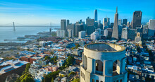 Aerial Of Roof Of Coit Tower Overlooking Downtown Skyscrapers And Oakland Bay Bridge