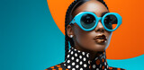 Fototapeta Natura - Fashionable glamour African black woman in sunglasses portrait isolated on blue and orange background