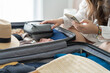 Woman packing suitcase on bed for a new journey packing list for travel planning preparing vacation Book Now Traveling Transportation