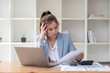 © wichayada - Confused Asian woman thinking hard about how to solve problems online looking at laptop screen. Serious Asian businesswoman worried focused on solving difficult computer at office