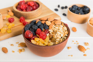 Canvas Print - Cooking a wholesome breakfast. Granola with Various dried fruits and nuts in a bowl. The concept of a healthy dessert. Flat lay, top view with copy space