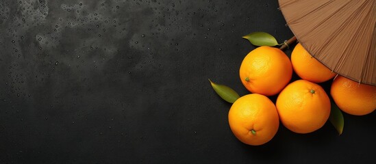 Wall Mural - Black plate with two oranges and umbrella isolated on a isolated pastel background Copy space